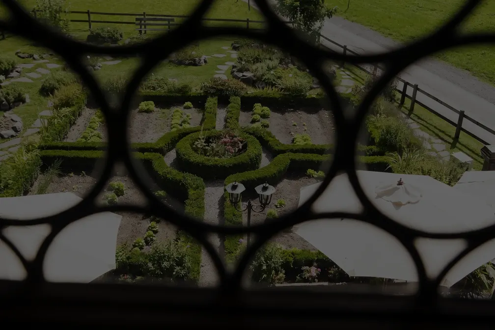 Blick durch das Fenstergitter auf den Ziergarten