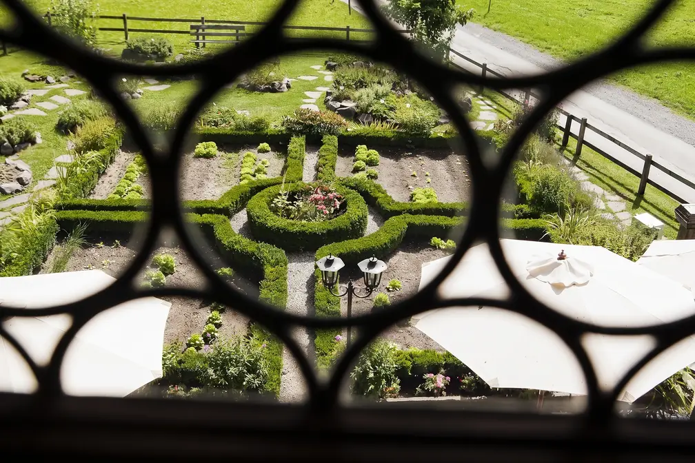 Blick durch das Fenstergitter auf den Ziergarten