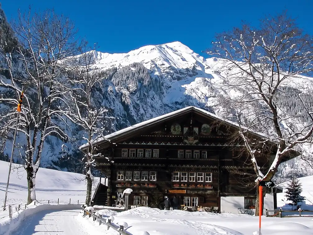 Das Haus im Schnee, dahinter die Berge