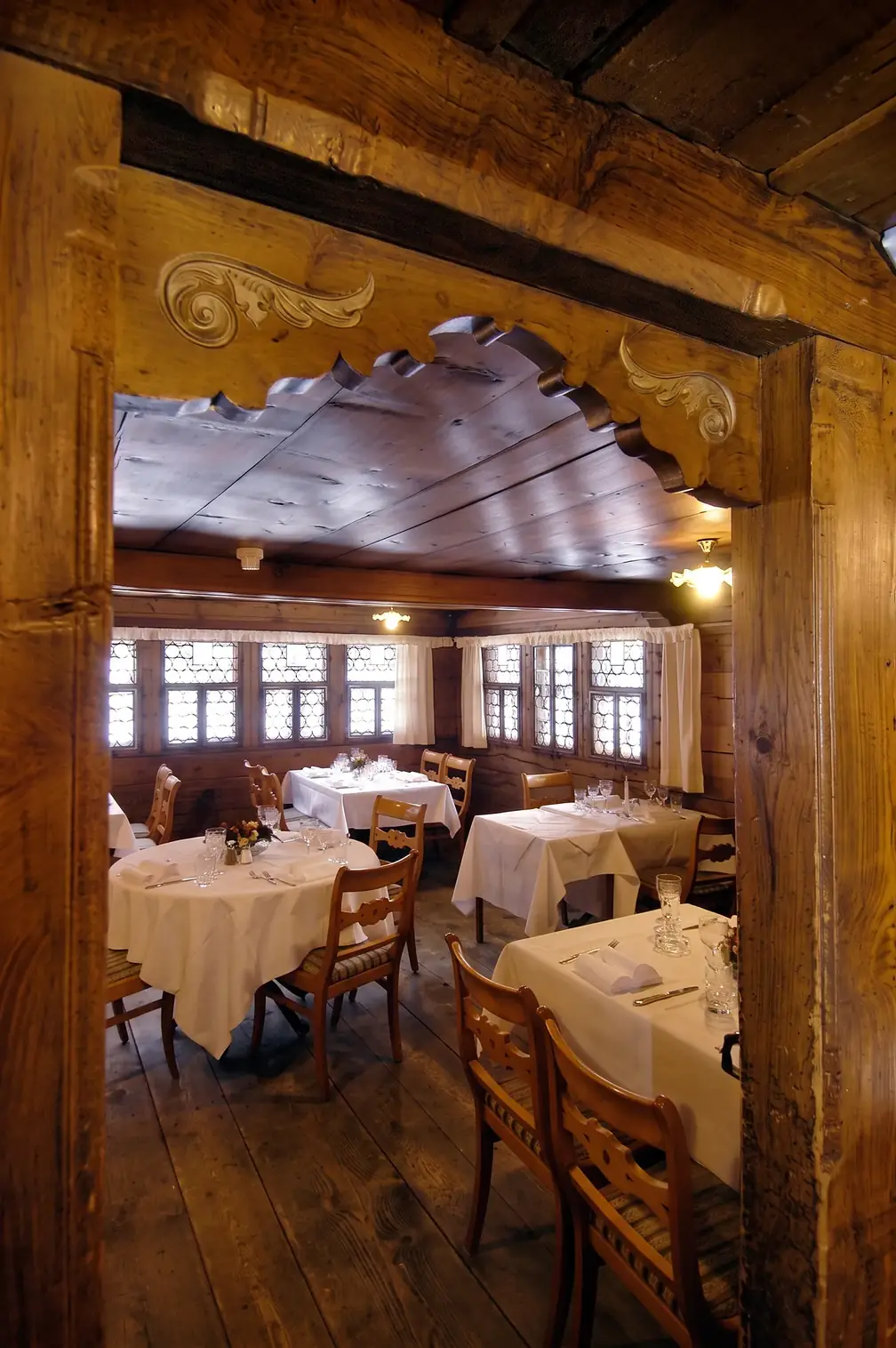 Blick durch die geschnitzte Tür in die Stube