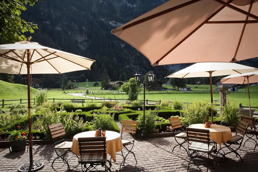 Gartentische unter Schirmen, Blick ins Tal
